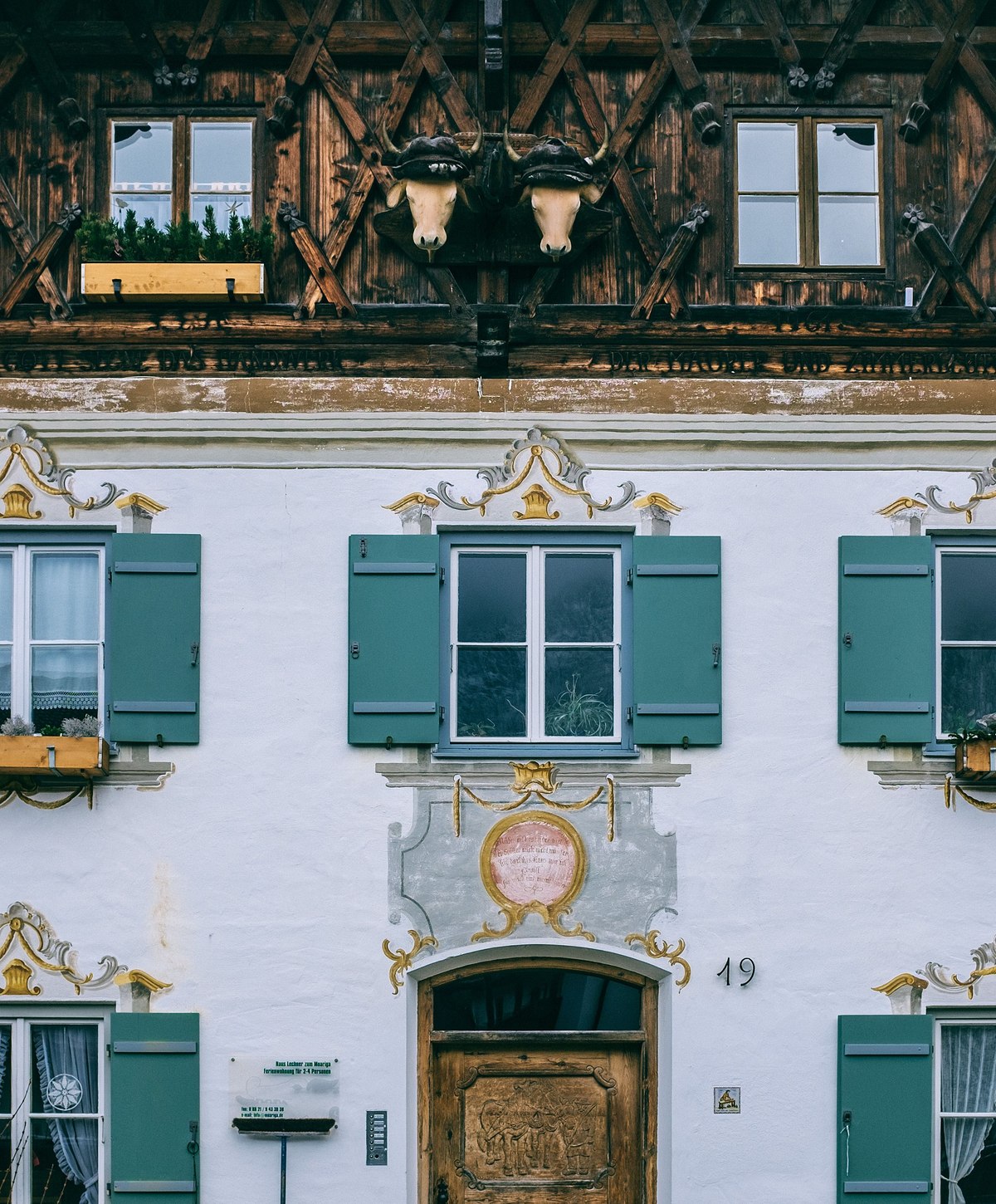 Gepflegte traditionelle Hausfassade mit grünen Fensterläden in Bayern